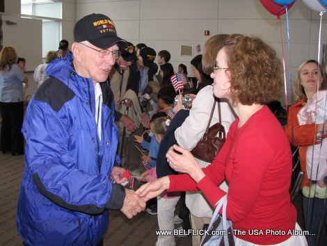 Photo of a World War II veteran greeting passengers at Washington Dulles Airport